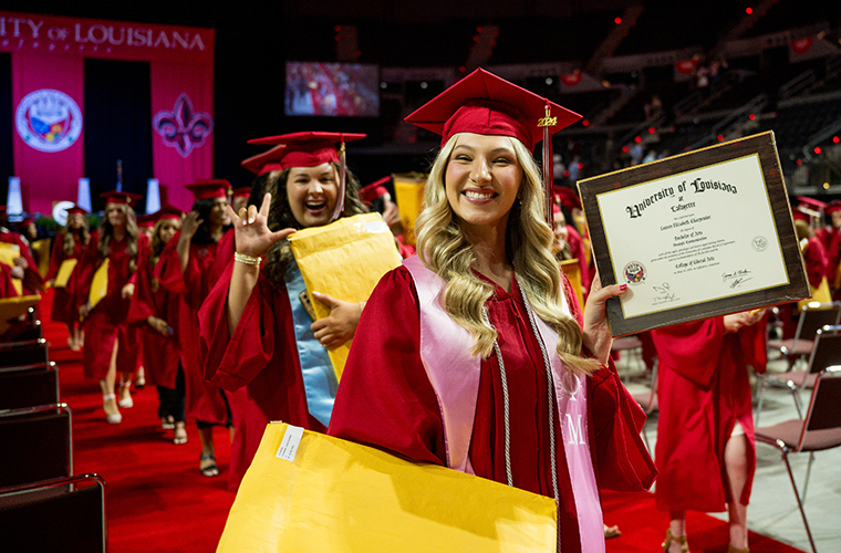 Student showing diploma at graduation ceremony